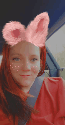 a woman wearing pink bunny ears on her head