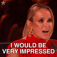 a woman in a red dress says " i would be very impressed " in front of a microphone