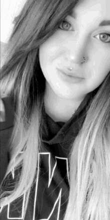 a woman with a nose ring is wearing a shirt that says jm