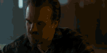 two men are standing next to each other in a dark room .