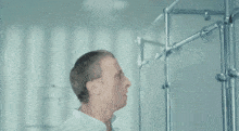 a man in a white lab coat is standing in front of a metal structure
