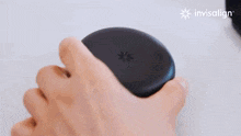 a person is holding a black invisalign product in their hand