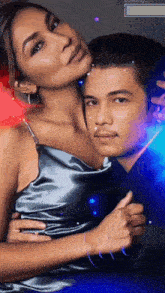 a man and a woman are posing for a picture and the woman is wearing a gray dress