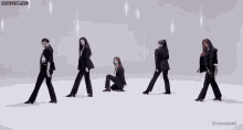 a group of women in suits are dancing together on a white background