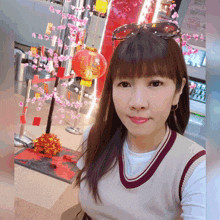 a woman wearing sunglasses takes a selfie in front of a red lantern
