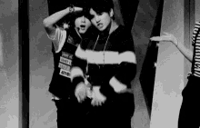 a couple of men are standing next to each other on a stage .