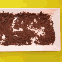 a white plate topped with chocolate shavings and the word ea