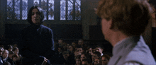 a man in a black coat stands in front of a crowd of people with a stained glass window behind him