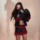 a woman wearing everlast boxing gloves stands in front of a wall