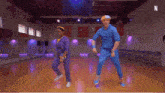 a man and a woman are dancing in a gym with the letter n on the bottom right