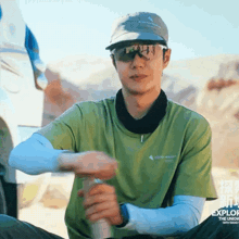 a man wearing sunglasses and a hat is sitting in the desert