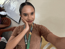 a woman taking a selfie with a lanyard that says " okinawa "