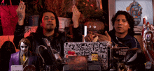 two men are sitting in front of a sign that says " el joker "
