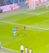 a group of soccer players on a field with a goalie in the background