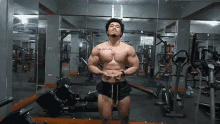 a man in a gym has a tattoo on his chest that says " i am still standing "