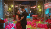 a man and a woman are standing in a room with balloons and a sign that says i love you