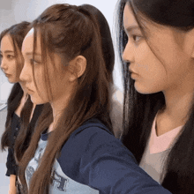 three girls are standing next to each other and one is wearing a shirt that says ' a ' on it