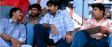 a group of men are sitting in a row talking to each other