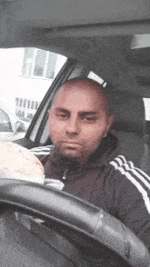 a man sitting in a car holding a tortilla
