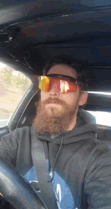 a man with a beard wearing sunglasses and a hoodie