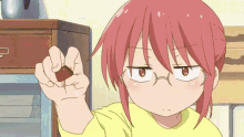 a girl with red hair is holding a chocolate bar in her hand .