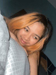 a woman laying on a bed with her head on a blanket