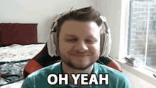 a man wearing headphones is smiling and saying `` oh yeah '' while sitting in a chair .