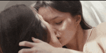 a couple of women kissing each other on the forehead