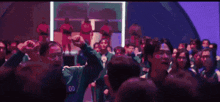 a crowd of people with their arms in the air and a man wearing a number o shirt