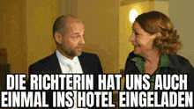 a man and a woman are standing next to each other in a room and laughing .