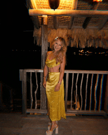a woman in a yellow dress is standing on a balcony