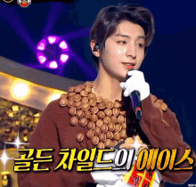 a man holding a microphone with a sweater made of chocolate coins