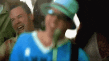 a blurry picture of a man wearing a blue shirt that says ' a ' on the front