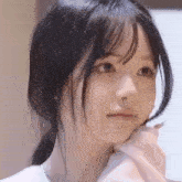a close up of a girl 's face with a ponytail and bangs .