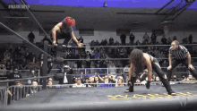 two wrestlers in a ring with the words #warrior19 on the bottom