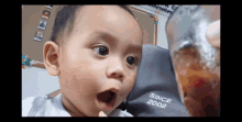 a baby with a surprised look on his face is wearing a since 2002 sweatshirt