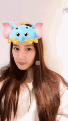 a woman wearing a blue elephant hat with a crown on top