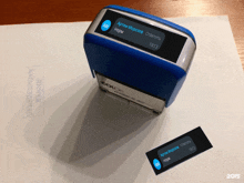 a blue and silver colop brand stamp sits on a white piece of paper