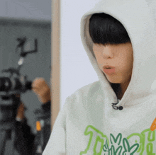 a close up of a person wearing a hoodie with a camera in the background .
