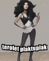 a woman in a black and white swimsuit stands with her hands on her hips and the words terolet plaktuplak above her