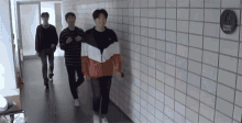 a group of young men are walking down a hallway next to a sign that says cactus garden .