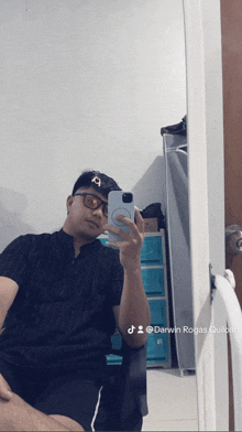 a man is taking a selfie in front of a mirror with darwin rogas written below him