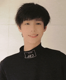 a young boy wearing a black sweater with the word csr on the collar