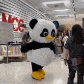 a panda mascot in front of a sign that says mcc