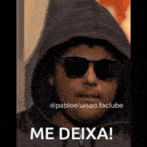 a man wearing sunglasses and a hoodie says me deixa on the bottom