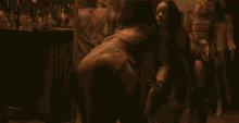 a group of people are dancing in a dark room with lights behind them