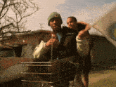 a man wearing a wolf jacket is pushing a man in a shopping cart