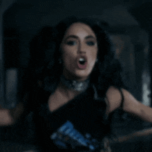 a woman in a black dress is holding a rope