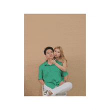 a man and a woman are posing for a picture while sitting next to each other .