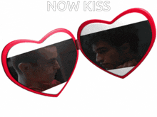 a pair of red heart shaped sunglasses with the words now kiss on the top
